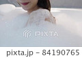Closeup cheerful Asian woman blowing foam in bathtub. Side view of smiling female relaxing in bathtub. 4K slow motion footage. 84190765