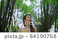 Happy Asian woman walking under beautiful bamboo forest. Female traveling eco-tourism 84190768