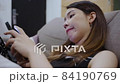 Unhappy Asian woman using a smartphone sitting on the sofa with negative facial expression 84190769