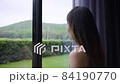 Asian woman opening curtains in hotel room looking out window after check-in for vacation trip 84190770