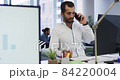 Caucasian businesswoman standing in discussion with two mixed race male colleagues at their desk 84220004