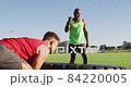 Fit sweaty caucasian man exercising on training bike inside gym 84220005