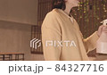 Asian Woman Spraying Water on Home Plants 84327716