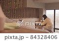 Woman Dusting Furniture in Bedroom 84328406