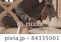 Man Using Screwdriver while Assembling Furniture 84335001