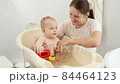 Smiling mother holding her little baby son playing with toy boats in bathroom. Concept of children hygiene, healthcare and parenting. 84464123
