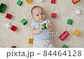 Portrait of cute baby boy palying with colroful bricks and blocks looking up in camera. Concept of children development, education and creativity at home 84464128