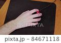 young male gamer hand on computer mouse moving in slow motion on black mouse pad 84671118