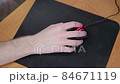 young male gamer hand on computer mouse moving in slow motion on black mouse pad 84671119
