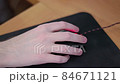 young male gamer hand on computer mouse moving in slow motion on black mouse pad 84671121
