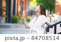 Young beautiful woman gets her face refreshed in hot day 84708514