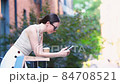 Happy woman with smartphone in european street. Young attractive tourist outdoors in the city 84708521