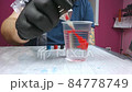 Tattoo artist washes the needle tattoo machine in a glass of water 84778749