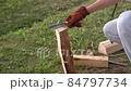 A man chopping wood with a hatchet at a campsite 84797734