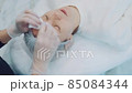 cosmetologist removes remains of cosmetic face product, from female face with special wet wipes 85084344