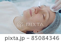 Closeup face young woman who takes cosmetic facial procedure. Beauty therapy. Cosmetology skin care 85084346