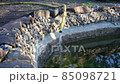 Small garden pond with stone banks is filled with water	 85098721