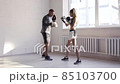 Father is preparing his young daughter for mixed martial arts competitions. The girl hits a punching bag 85103700