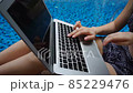 Close up hands chatting with laptop keyboard near swimming pool. 85229476