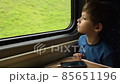 Young traveler looking through train window 85651196