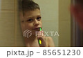 Child brushing teeth looking in mirror 85651230