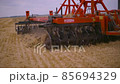 Harvesting in the field. Land cultivation with a tractor 85694329