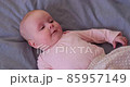 Sneezing caucasian baby lying on bed. 85957149