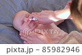 Woman using nasal spray for baby 85982946