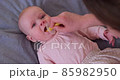 Mom helps to brush the teeth of a caucasian baby 85982950