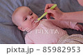 Caucasian mother giving liquid medicine to her baby. Healthcare and child treatment concept. 85982953