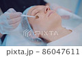 Close up of cosmetologist hands put moisturizer butter on girl face by brush. Cosmetic procedure  86047611