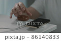 A man's hand carrying a charged wireless earphone 86140833