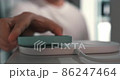 A man who puts a smartphone on a wireless charging pad and charges it 86247464
