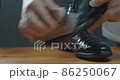 Men brushing black business shoes for maintenance shoe care 86250067