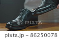 Men brushing black business shoes for maintenance shoe care 86250078