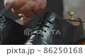 Maintenance of black business shoes Men preparing to loosen their laces for shoe care 86250168