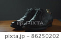 A man who inserts a wooden shoe tree into his shoes to prevent the black business shoes from getting out of shape 86250202