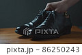 A man who carefully brushes black business shoes 86250243
