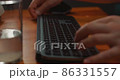 A close-up of a man's hand typing characters with a black keyboard at home. Slow motion 86331557