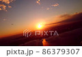 日没直前の羽田空港を夕日を浴びて離陸する飛行機から見えるマジックアワーの東京の風景 86379307