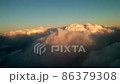 日没直前の雲の上を飛ぶ飛行機からの夕焼けに染まる雲の眺め 86379308