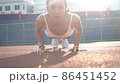Push ups or press ups exercise by young asian woman. Girl working out on track field crossfit strength training in the glow of the morning sun against. Sport model people concept. slow motion shot. 86451452