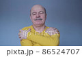 Confident smiling man holding hugging himself isolated on blue wall background 86524707