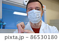 Confident doctor man in mask talking look at camera in hospital 86530180