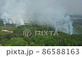 Large smoke clouds and fire spread. Aerial view of smoking wild fire 86588163