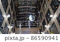 A mirrored disco ball suspended from the ceiling inside a high-rise building. 86590941