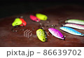Spinners of different colors and shapes for fishing on a brown table. Background in blur. 86639702