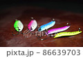 Spinners of different colors and shapes for fishing on a brown table. Background in blur. 86639703