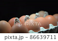 Eggs close up in egg protective container on black background. Foreground and background in blur. Focus in the center. 86639711