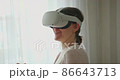 Young female in VR goggles experiencing virtual world 86643713